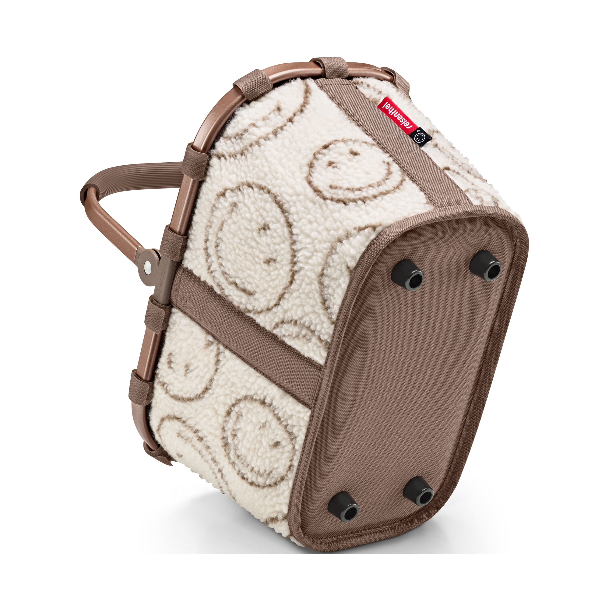 Kleiner Einkaufskorb von Reisenthel, Modell Carrybag XS, in Creme und Braun mit Smiley-Muster aus Teddyfleece, schräg von unten mit sichtbaren Standfüßen