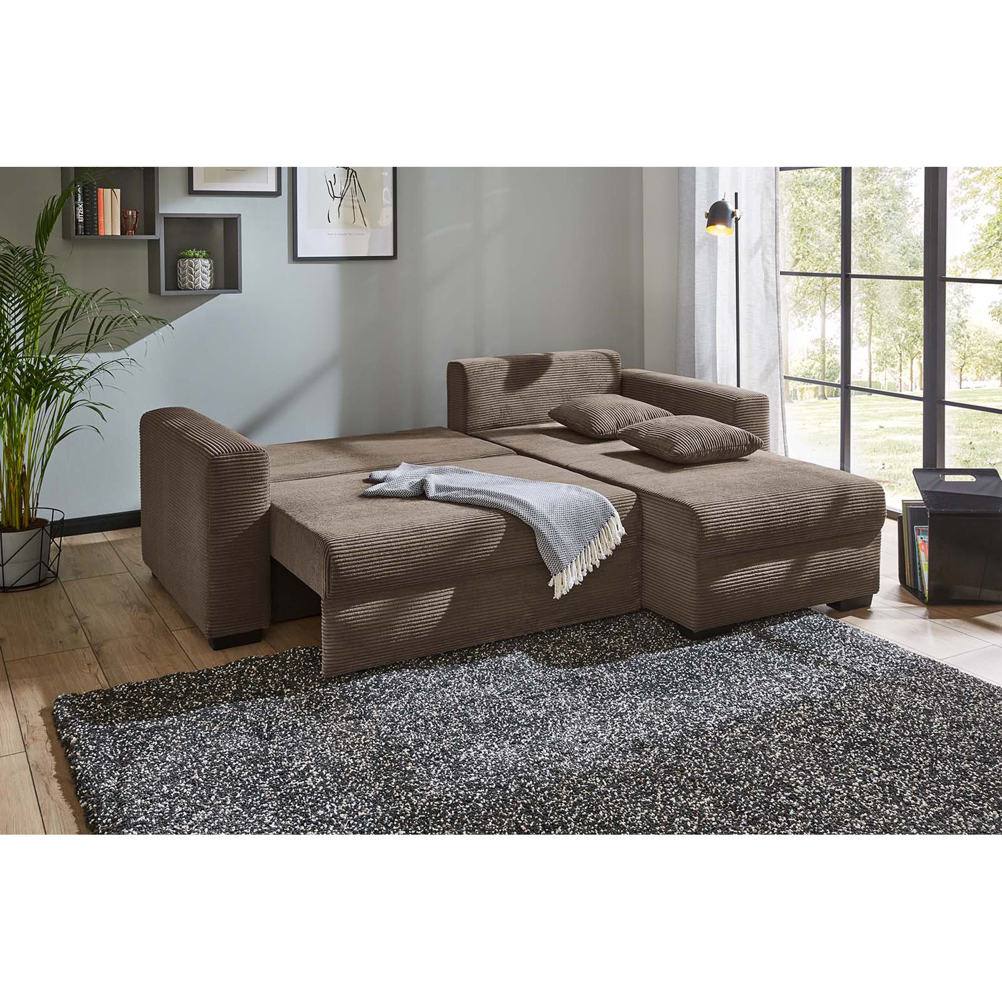 Braunes Ecksofa mit ausgeklappter Liegefläche und Ottomane in modernem Wohnzimmer