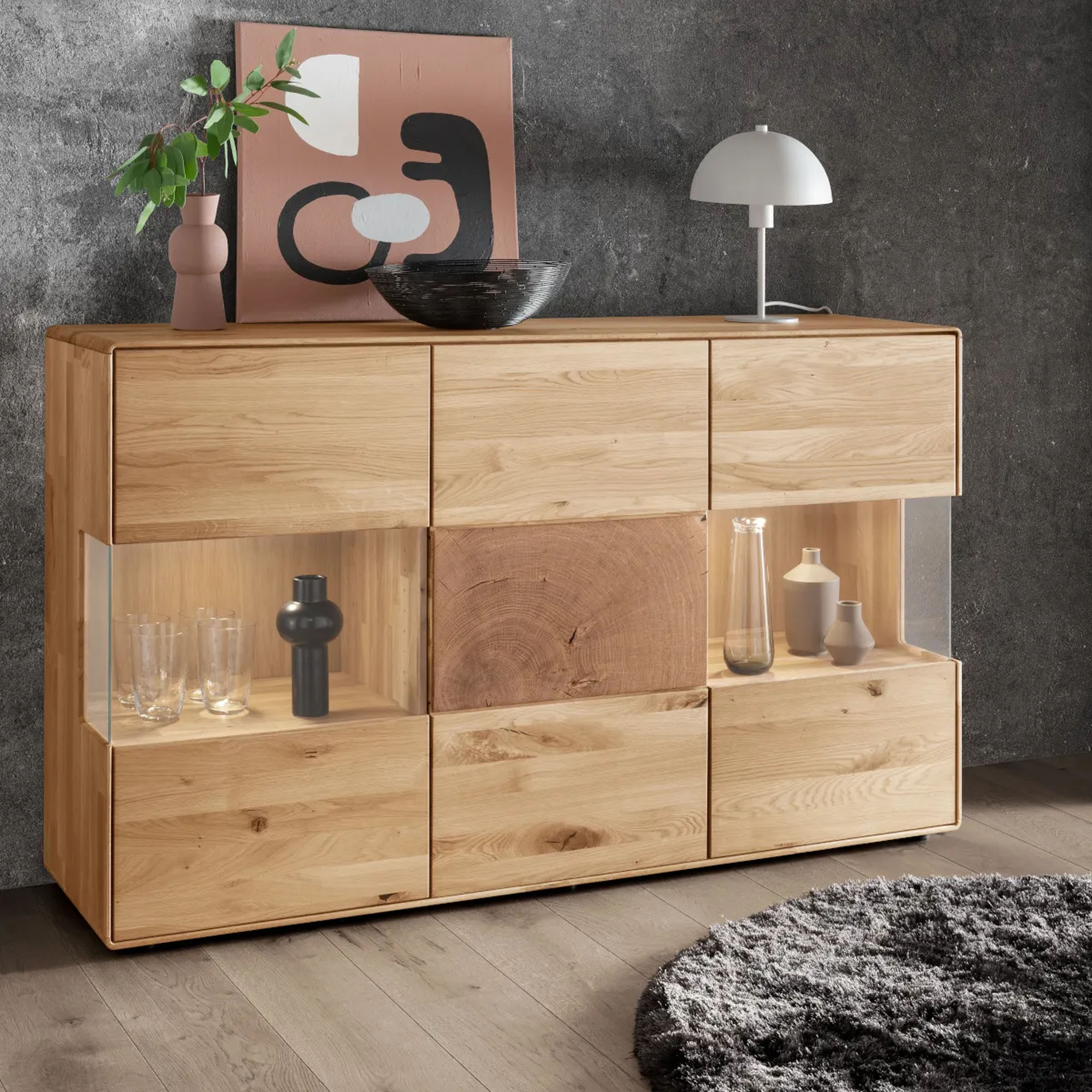 Sideboard aus Holz mit Türen Schubladen und offenen Fächern in einem Wohnraum mit Wanddekoration und Teppich