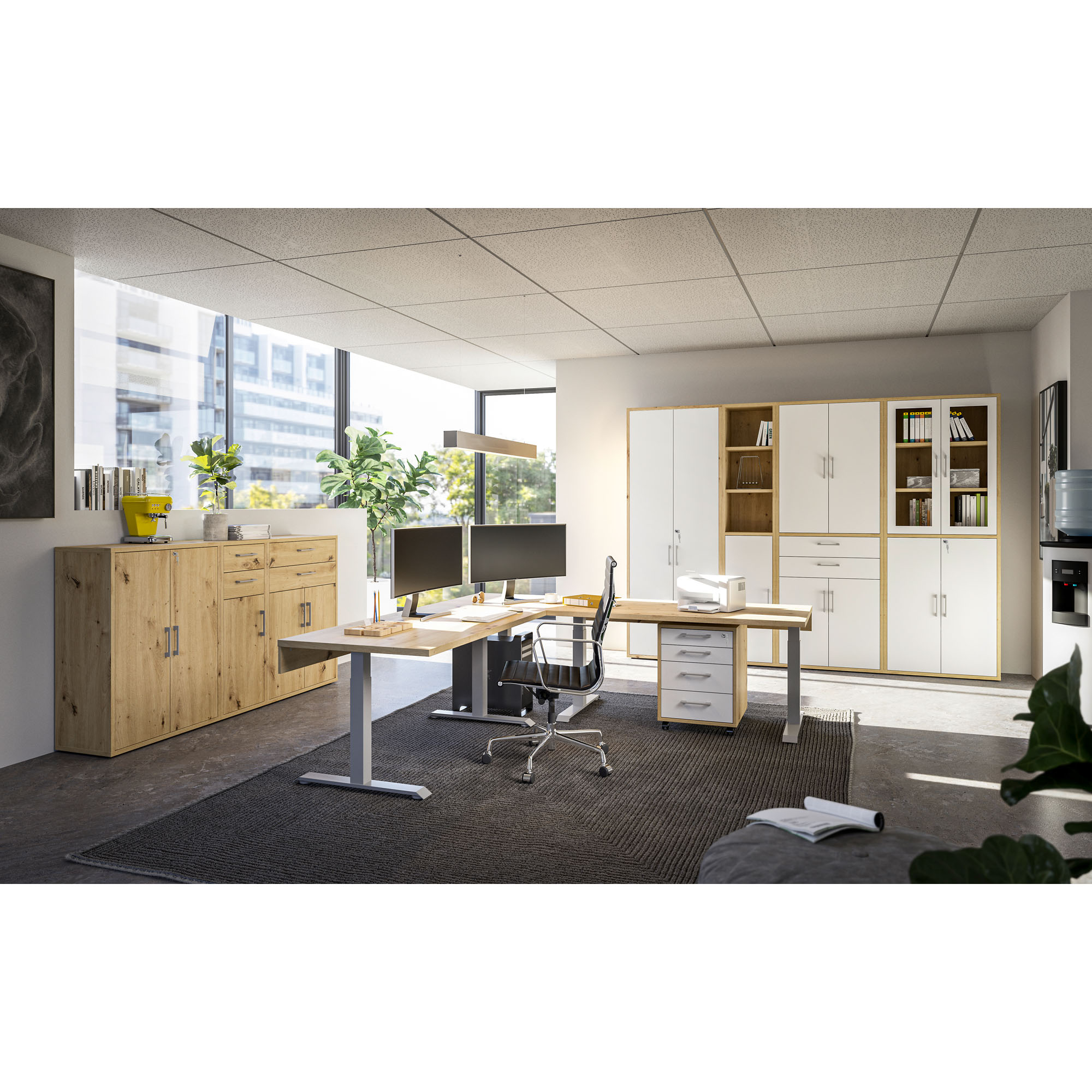 Modernes Büro mit Schreibtischen, Regalen und Schränken in Holz und Weiß, zwei Monitore auf dem Schreibtisch, große Fenster mit Blick auf Gebäude und Pflanzen im Raum