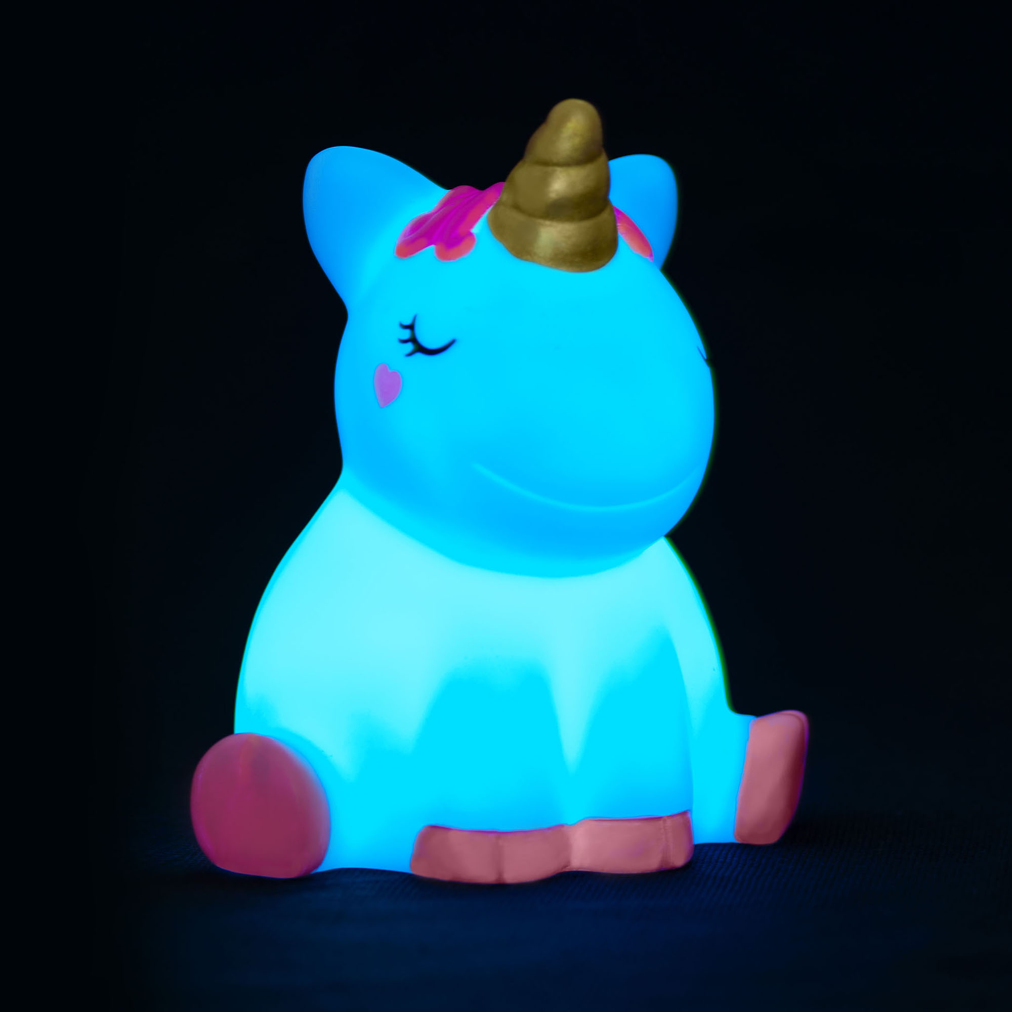 Nachtlicht in Einhornform, vor schwarzem Hintergrund blau leuchtend gezeigt.