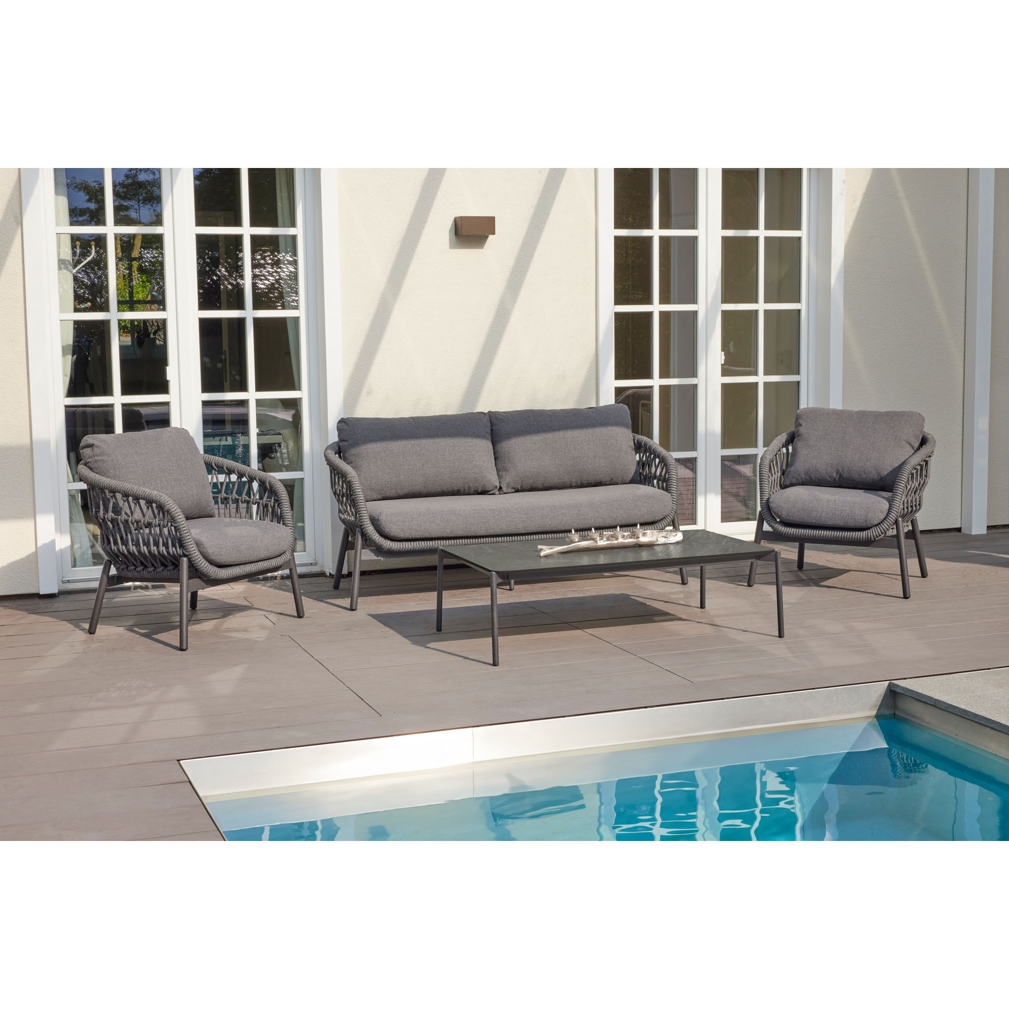 Loungeset mit Sofa und Sesseln auf einer Terrasse am Pool