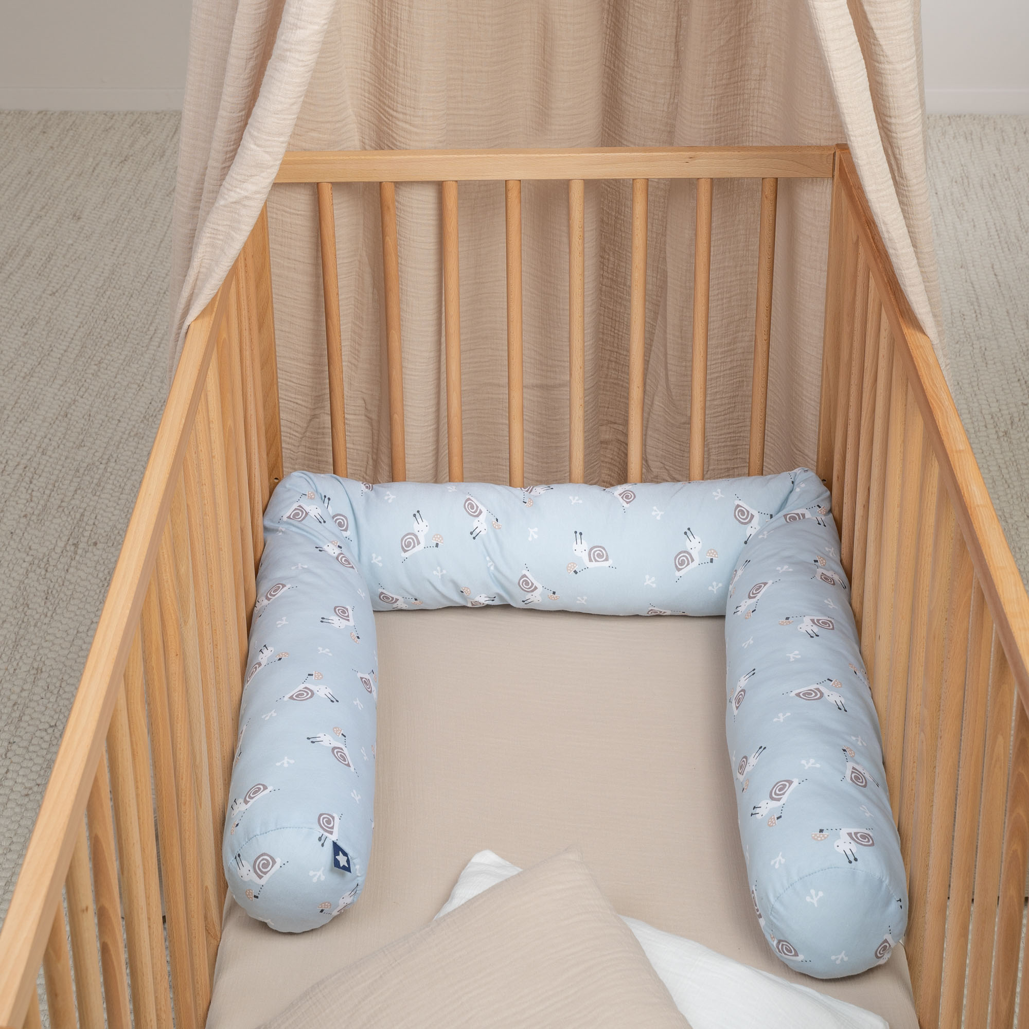 Blaue Baby Bettschlange mit Tiermotiven als Polsterung im Kinderbett