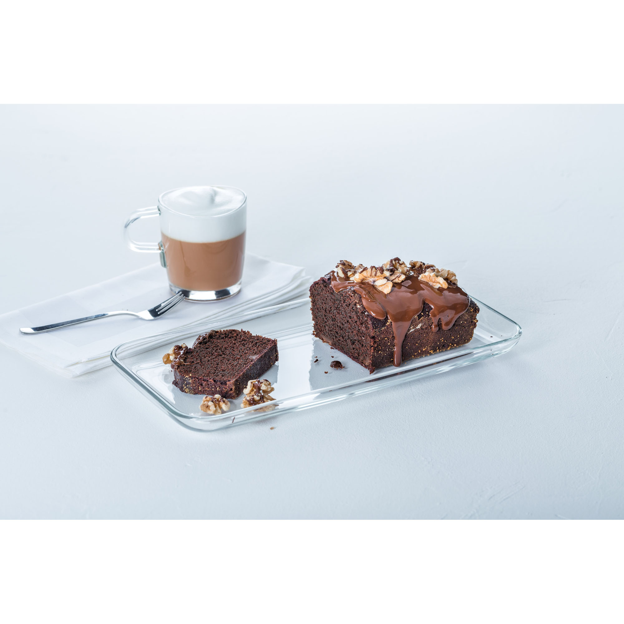 Glas Servierplatte mit Schokoladenkuchen und Tasse Kaffee auf hellem Hintergrund