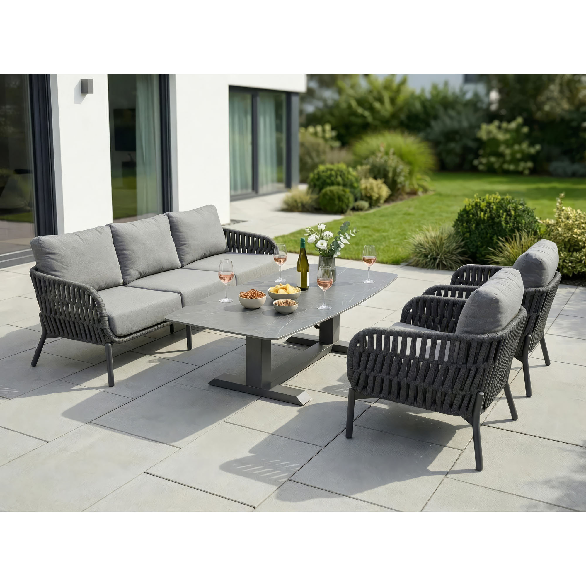 Loungesofa mit Tisch und weiteren Sitzmöbeln auf einer Terrasse im Außenbereich