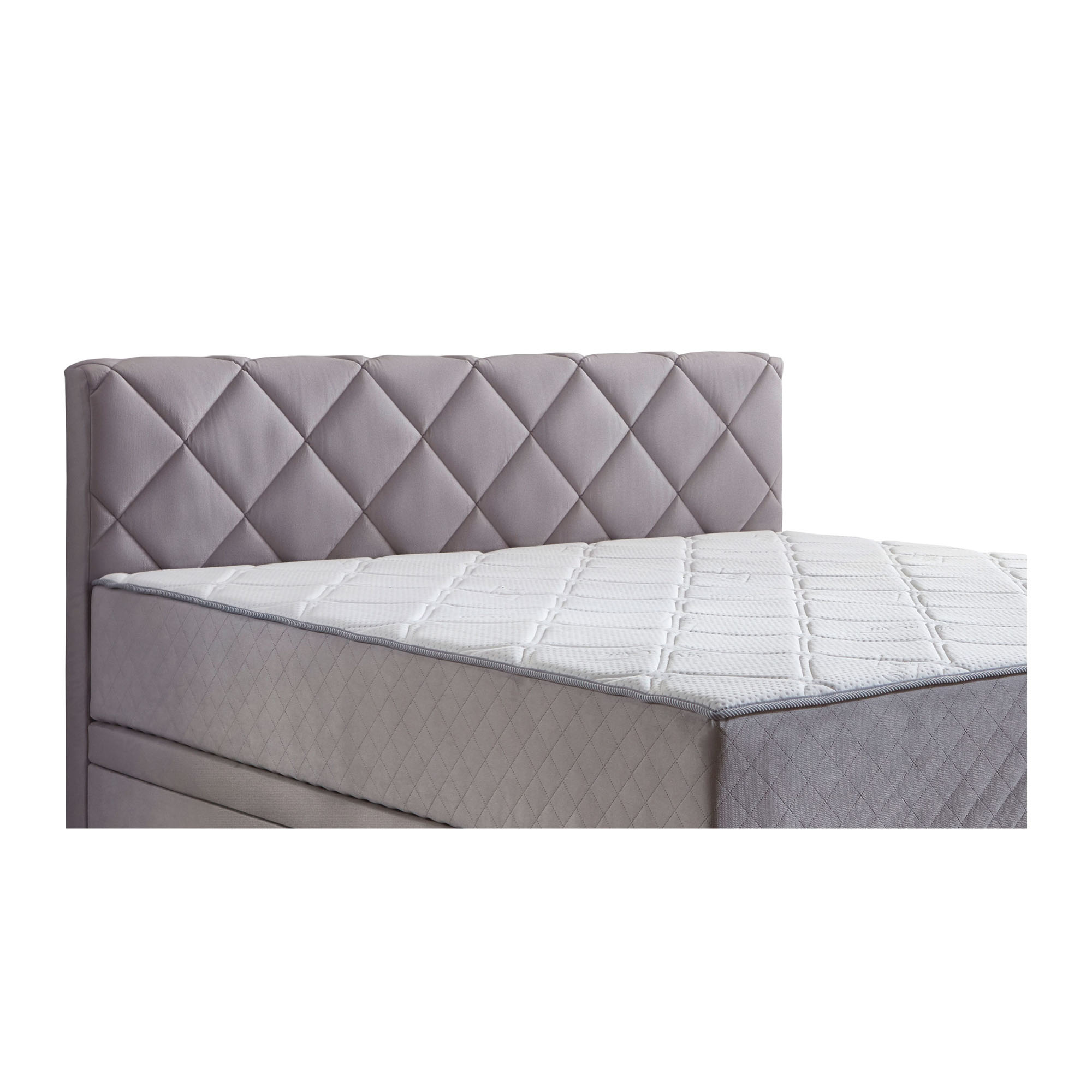 Nahaufnahme eines fest vernähten Matratzentoppers auf einem Boxspringbett