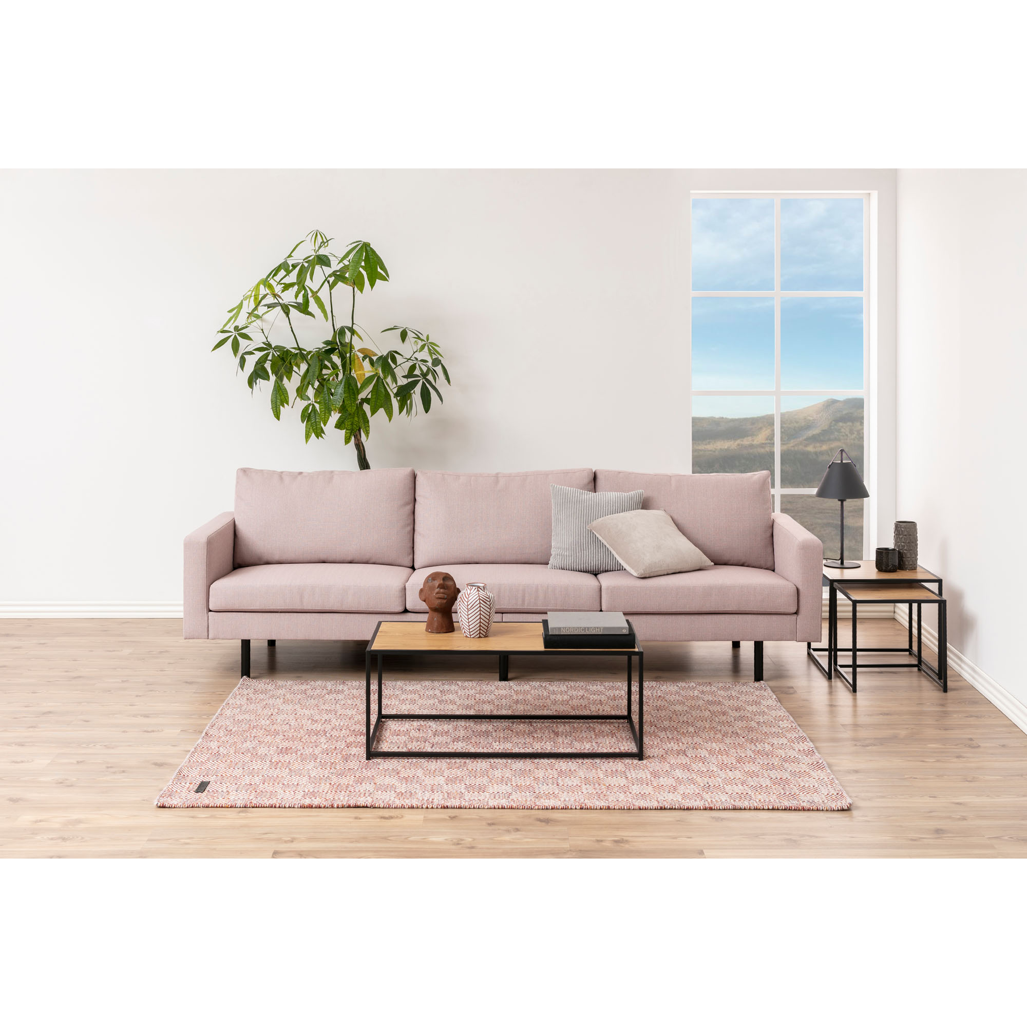 Couchtisch mit Platte in Wildeiche und mattschwarzem Gestell in einem eingerichteten Wohnzimmer, dekoriert mit Vase und Büchern