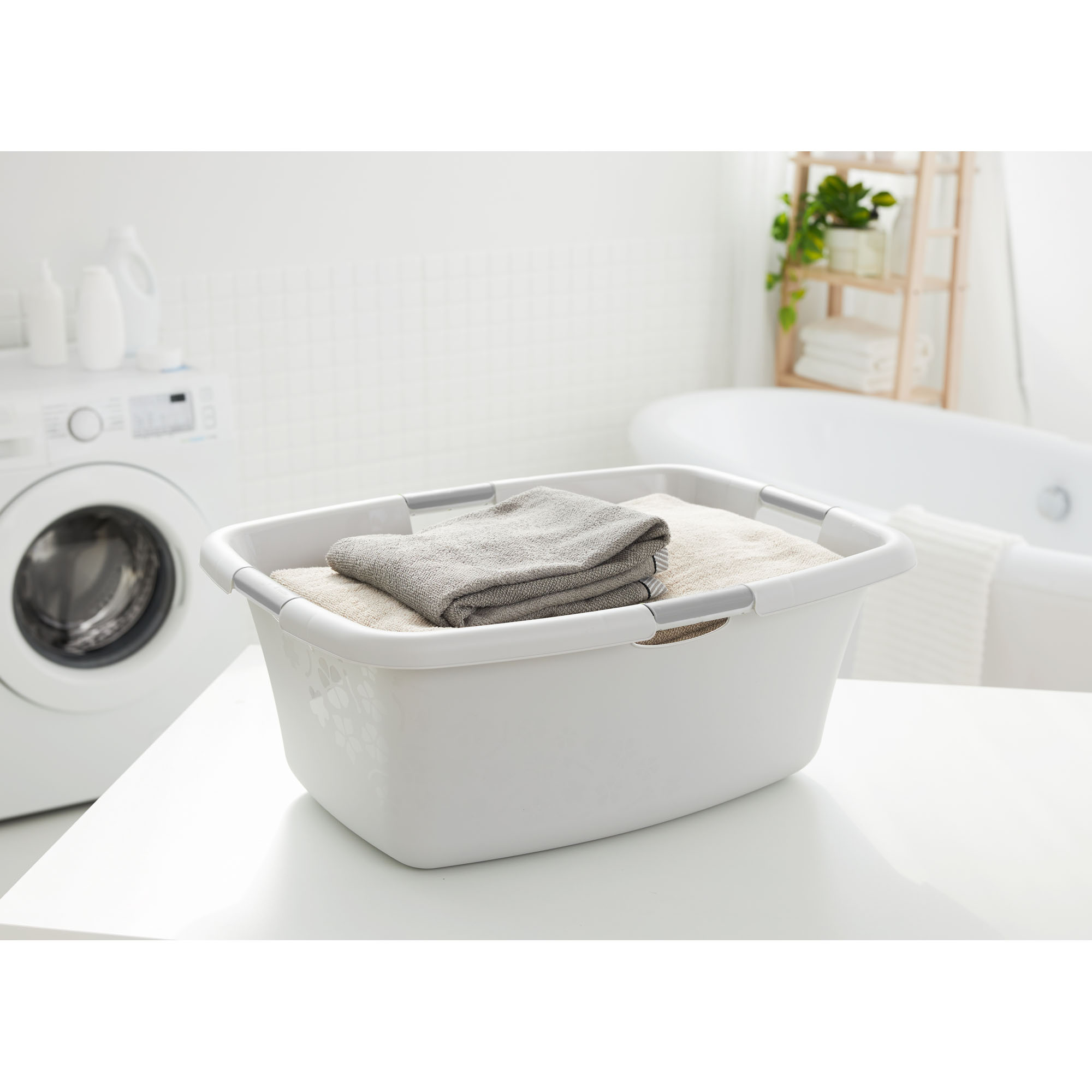 Graue Wäschewanne aus Kunststoff auf einem Tisch im Badezimmer neben einer Waschmaschine