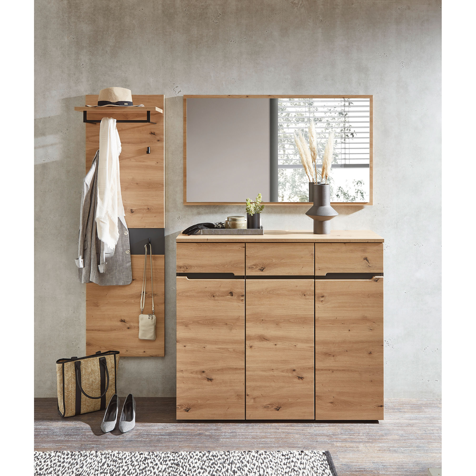 Eingestellter Eingangsbereich mit Holz-Wandpaneel, Spiegel und breiter Kommode aus Holzoptik, ergänzt durch Kleidung, Tasche und Dekoration.