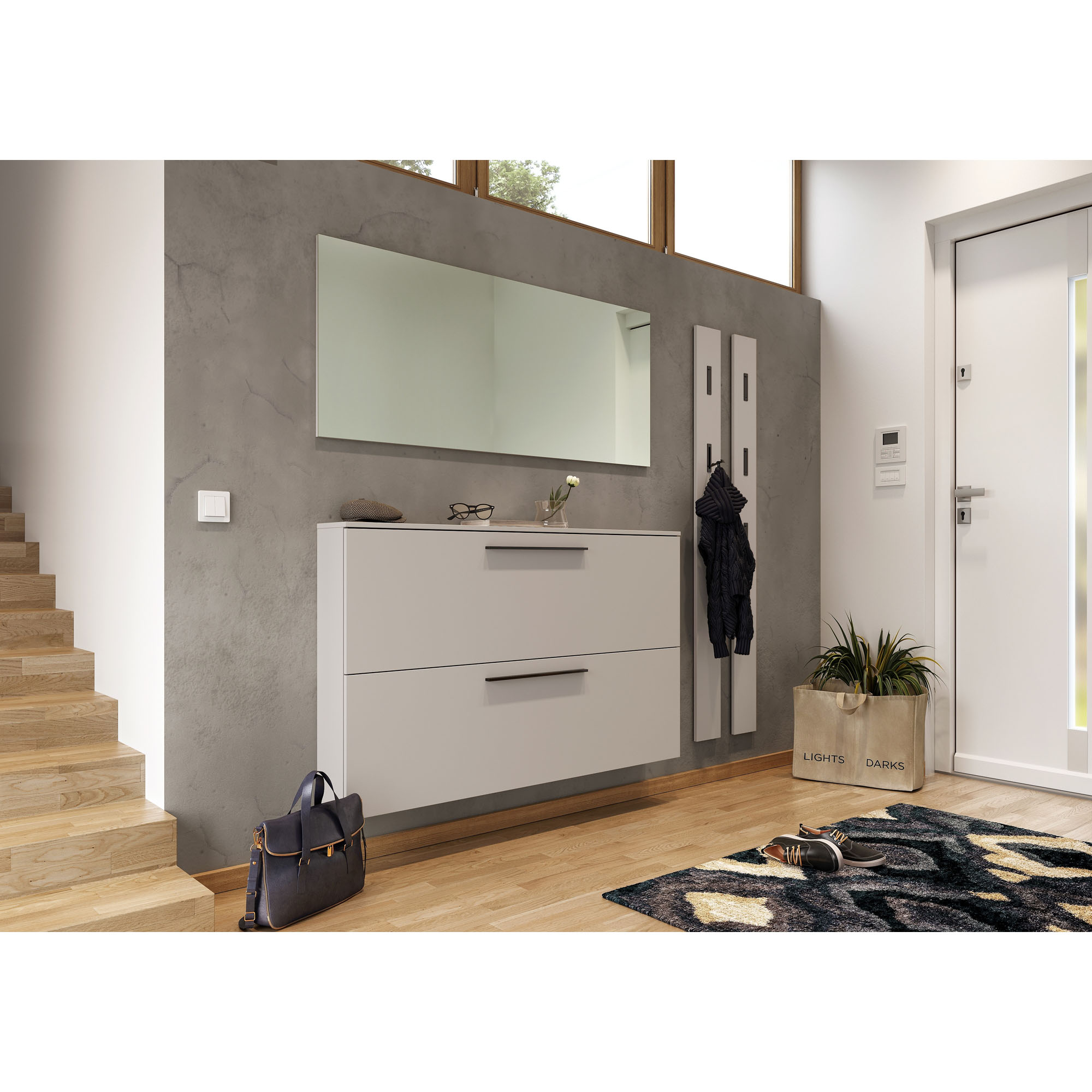 Schuhschrank mit zwei Klappen an einer grauen Wand montiert, darüber ein Wandspiegel und daneben zwei schmale Garderobenpaneele
