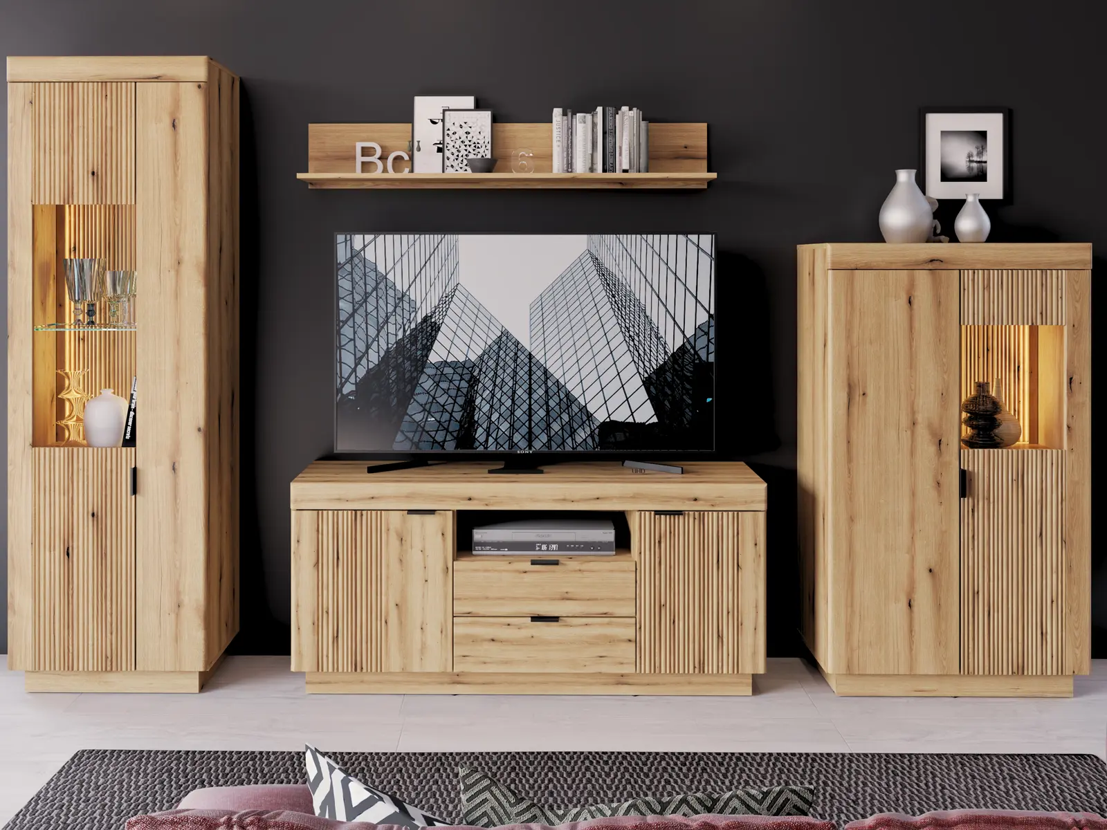 Delamar Wohnkombination in Eiche Artisan mit TV-Lowboard, zwei beleuchteten Vitrinen und Wandboard vor dunkler Akzentwand im modernen Wohnstil