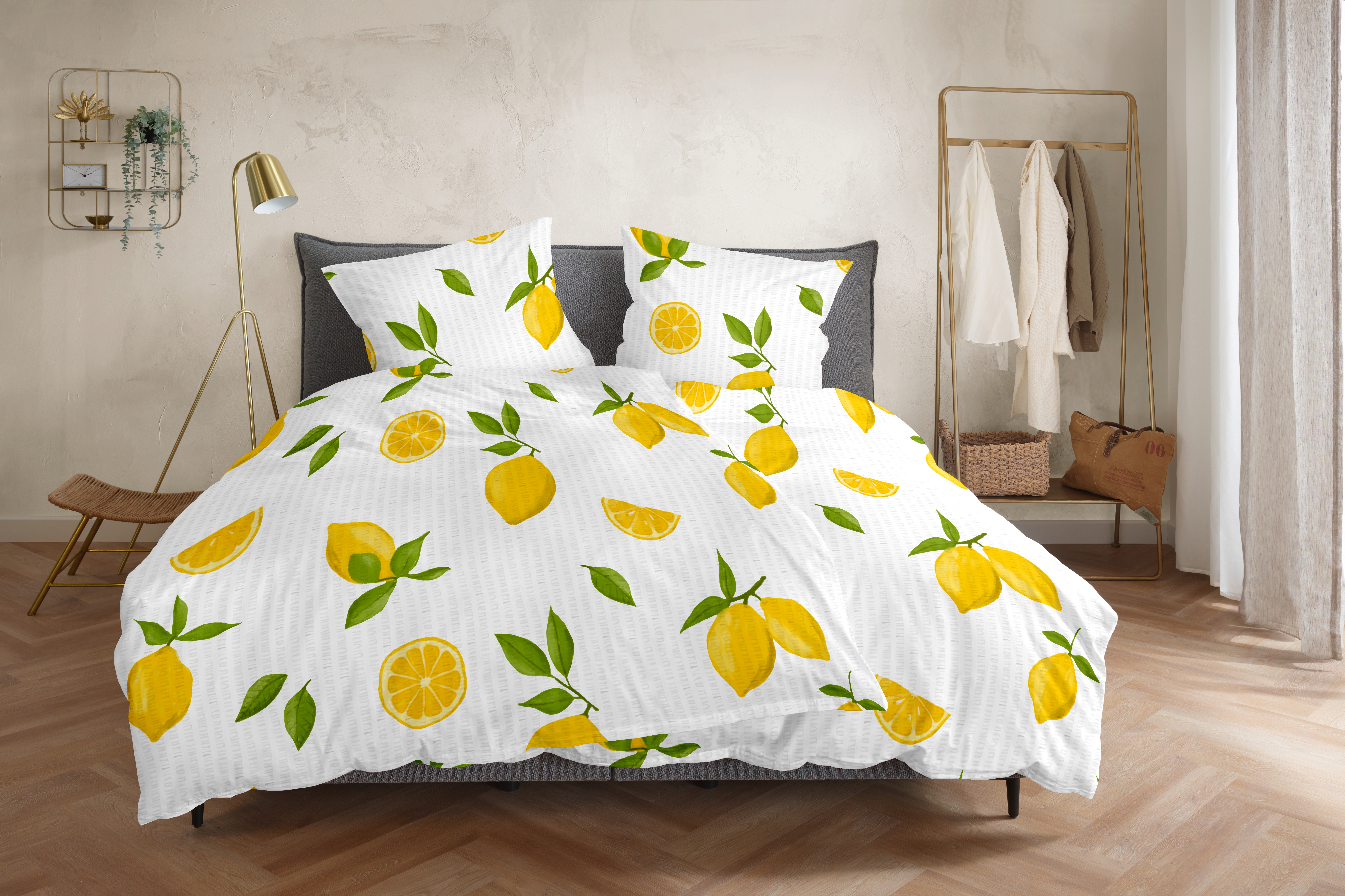 Doppelbett mit weißer Bettwäsche, bedruckt mit gelben Zitronen und grünen Blättern; Größe 135 x 200 cm.