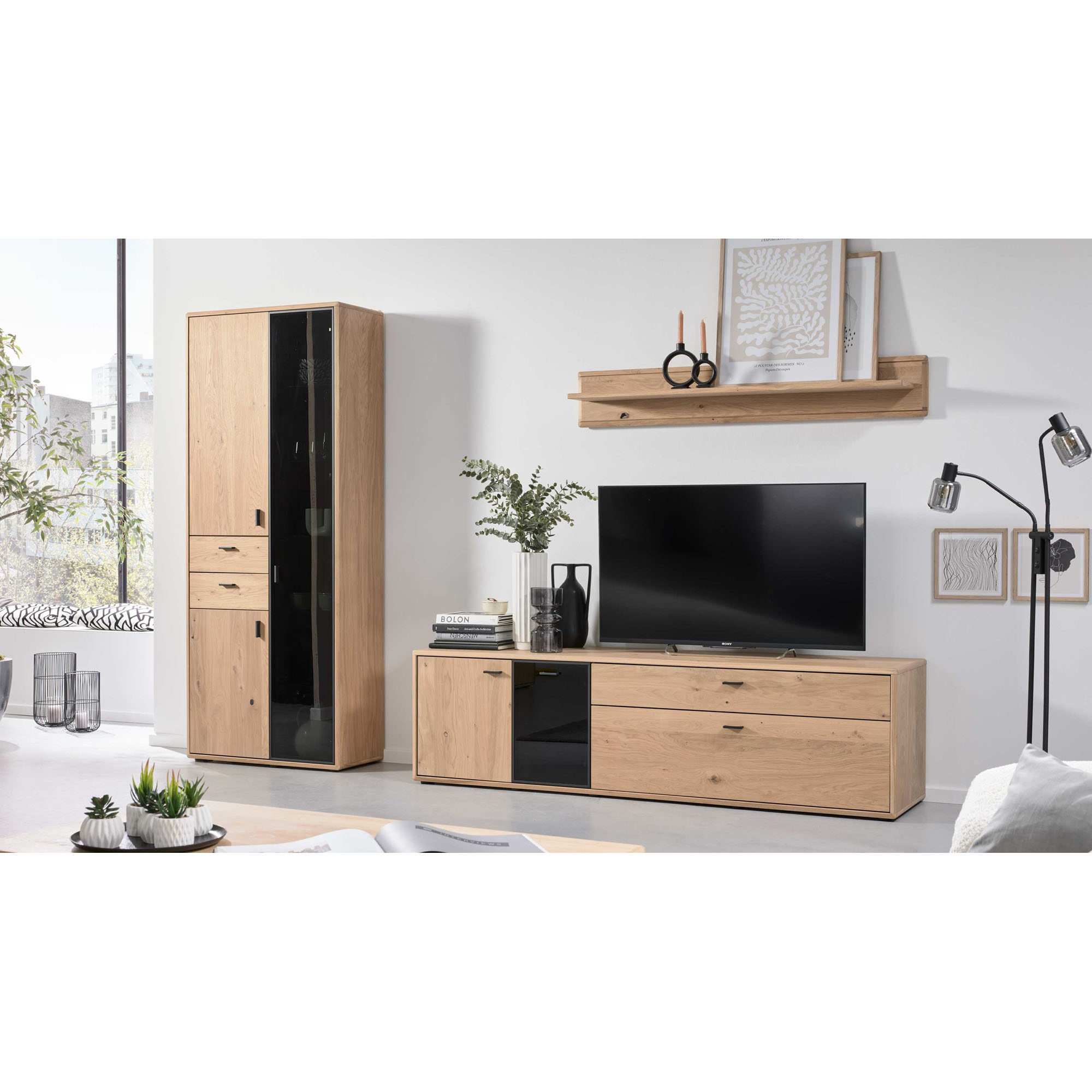 Interliving 2024 Wohnwand bestehend aus Vitrine, TV-Element und Wandboard in Eiche mit Glasdetails, dargestellt in Wohnraumsituation