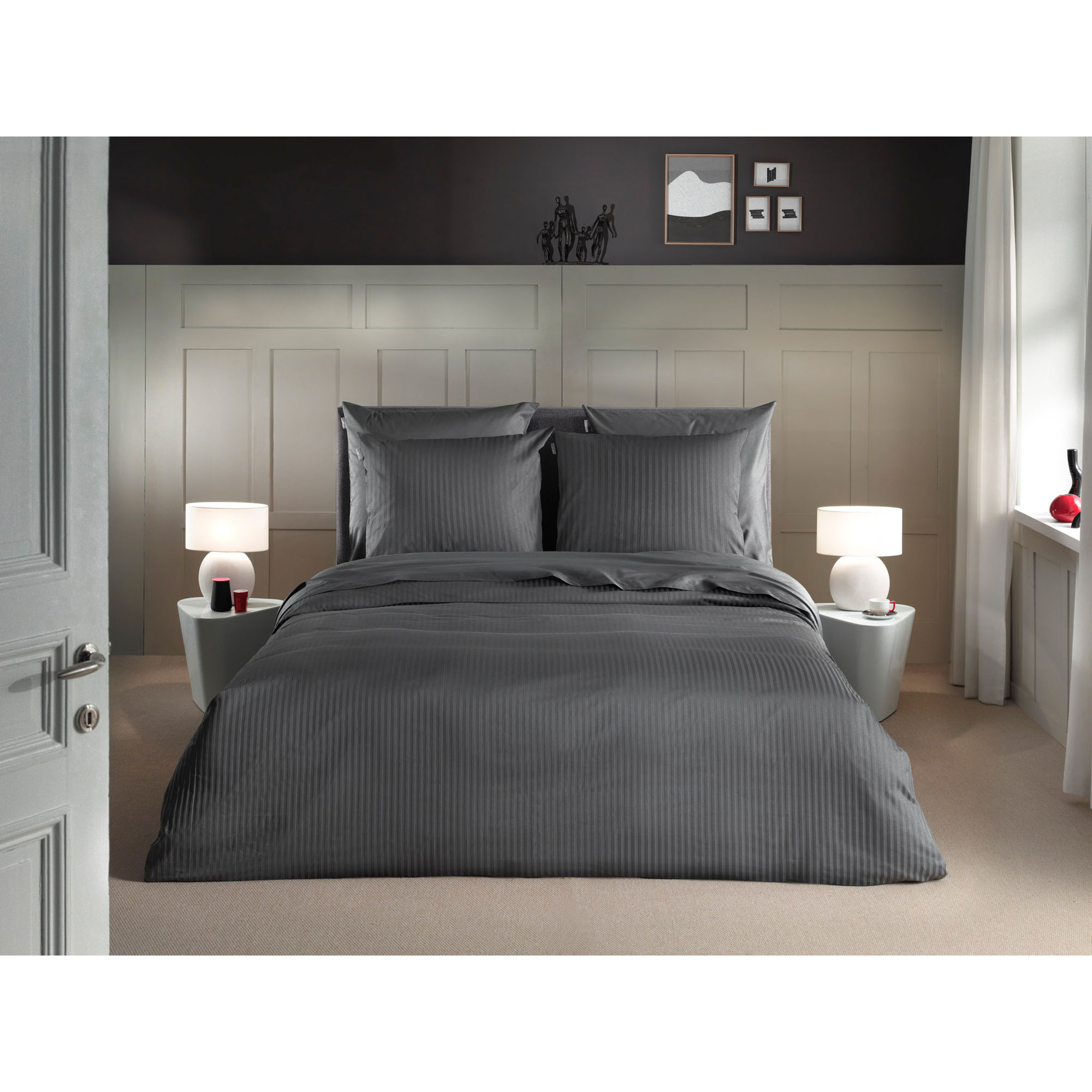 Bettwäsche Banda in Classic Anthracite, 155 x 220 cm: bezogenes Bett in frontaler Schlafzimmerszene mit feinen Längsstreifen.