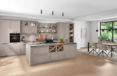 Klassische Landhausküche mit macciatofarbenen Rahmenfronten, Arbeitsplatte in Marmoroptik und liebevollen Details