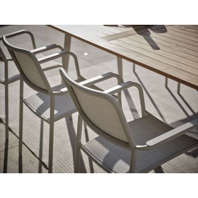 Zwei Gartenstühle mit Armlehnen an Tisch aus schräger Seitenansicht auf Terrasse