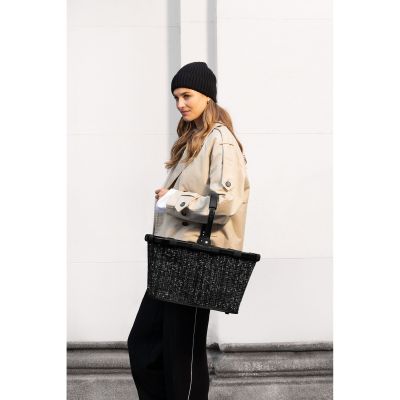 Einkaufskorb von Reisenthel, Modell Carrybag, in Schwarz mit Bouclé-Struktur, von einer Person am Tragegriff getragen