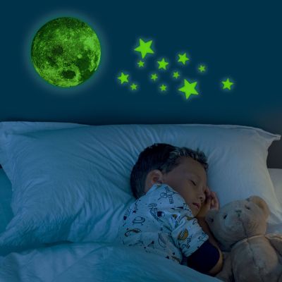 Set selbstklebender Leuchtsterne, leuchtend an der Wand über einem schlafenden Kind dargestellt.