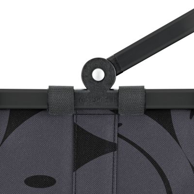 Kleiner Einkaufskorb von Reisenthel, Modell Carrybag XS, in Grau mit großflächigem Smiley-Muster, als Nahaufnahme des Gelenks am Griff.