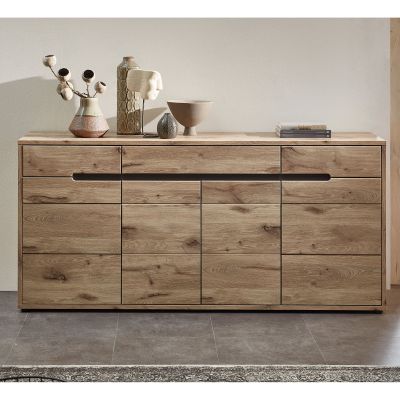Das Sideboard steht vor einer hellen Wand auf einem Fliesenboden. Oben darauf befinden sich mehrere Dekoobjekte und ein Bücherstapel.