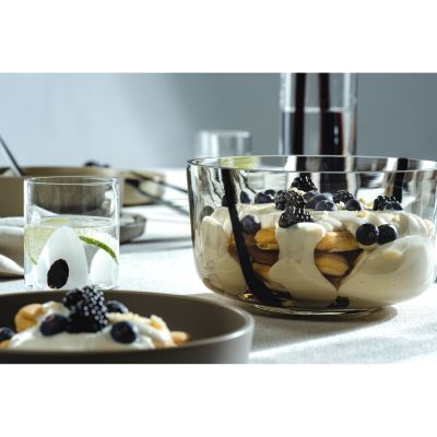 Glasschale gefüllt mit Dessert und Beeren auf gedecktem Tisch