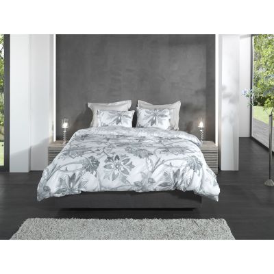 Bettwäsche Neva in Grey, 135 x 200 cm: bezogenes Bett in frontaler Schlafzimmerszene mit großen grauen Blumen- und Blättermotiven.