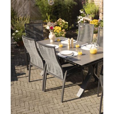 Mehrere Gartenstühle an einem gedeckten Tisch im Außenbereich