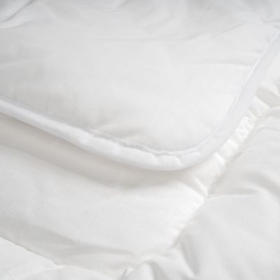Nahaufnahme einer weißen Steppdecke mit weicher Kante und glatter Oberfläche