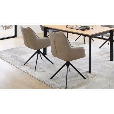 Beiger gepolsterter Stuhl auf schwarzem Drehgestell in einem Essbereich mit Tisch und Teppich