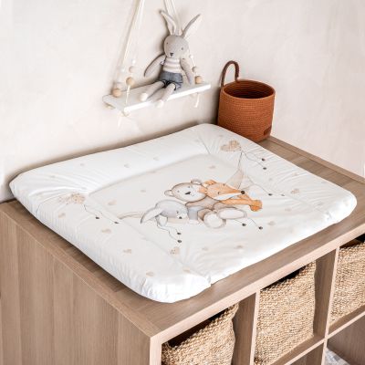Das Bild zeigt eine Wickelauflage mit Tiermotiv auf einer Holzkommode mit Körben, daneben dekorative Elemente