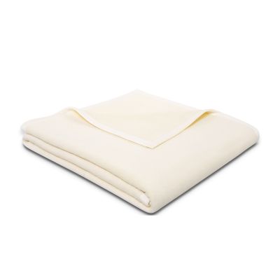 Gefaltete Wohndecke CottonSense natur in Cremeweiß mit schmal eingefasster Kante auf weißem Hintergrund.