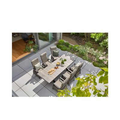 Großzügige Terrasse mit Esstisch und mehreren grauen Hochlehner-Gartenstühlen aus Polyrattan im Ensemble.