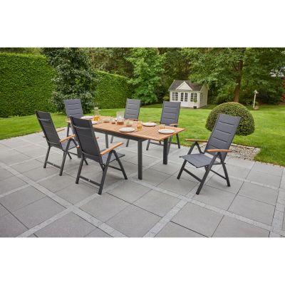Rechteckiger Gartentisch mit mehreren Gartenstühlen auf einer Terrasse im Garten