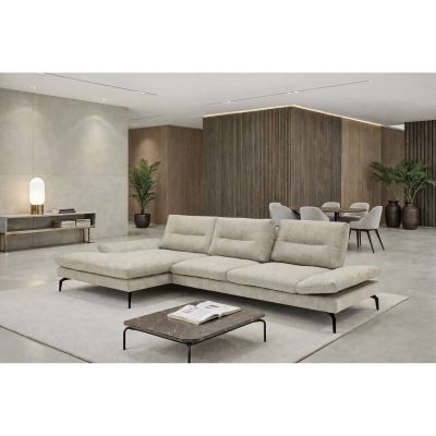 Beiges Ecksofa mit schwarzem Metallgestell und Ottomane links, inszeniert in einem modernen Wohnraum mit Couchtisch und Essbereich.