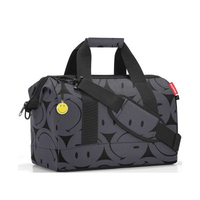 Reisetasche von Reisenthel, Modell Allrounder M, in Grau mit großflächigem Smiley-Muster, schräg von vorn mit Tragegriffen und Schultergurt.