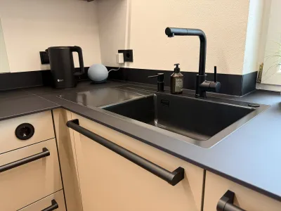 Detail Spüle und schwarzes mattes Spülbecken in Schüller Küche