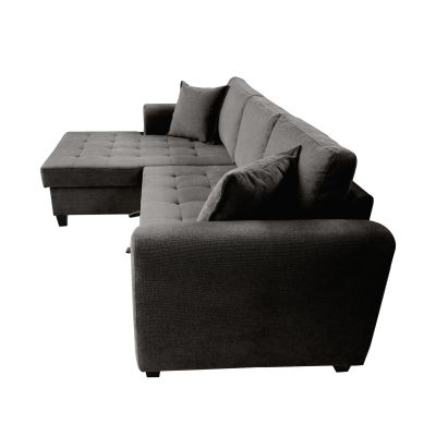 Freigestelltes graues Ecksofa aus erhöhter Seitenansicht mit abgerundeter Armlehne, gesteppten Sitzflächen, linker Ottomane und losen Kissen
