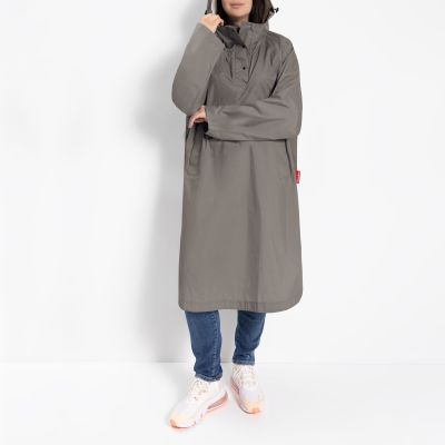 Frau trägt grauen wasserdichten Regenponcho von Reisenthel im lässigen Look