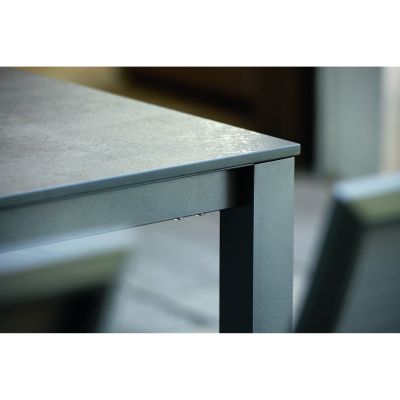 Nahaufnahme einer Tischkante mit sichtbarem Tischbein aus Metall