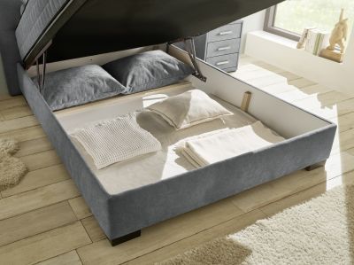 Detailaufnahme des geöffneten Bettkastens vom Boxspringbett „Wind 89 anthrazit“ in einem Schlafzimmer, Stauraum klar erkennbar