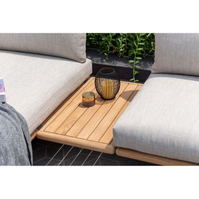 Ablageelement aus Holz zwischen zwei gepolsterten Garten Sofa Elementen mit Dekoration auf einer Terrasse