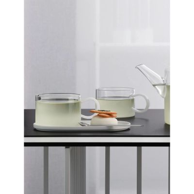 Tasse mit weißem Henkel der Serie Opal, Farbe Weiß matt in einer gedeckten Tischszene mit weiterem Geschirr.