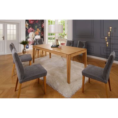 Quadratischer Esstisch aus Holz mit vier Stühlen in einem Esszimmer mit Teppich und Fenster im Hintergrund