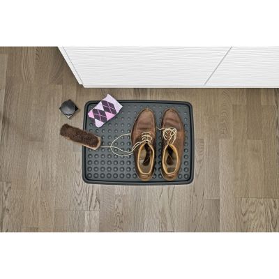 Schuhabtropfschale auf dem Boden mit einem Paar Schuhe und abgelegten Gegenständen darauf