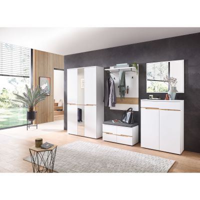 Heller Raum mit großem Fenster und weißem Garderoben-Set, bestehend aus Schrank, Wandpaneel, Sitzbank und Kommode, vor einer dunklen Wand platziert.