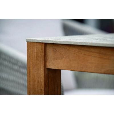 Detailansicht einer Tischecke mit massivem Holzrahmen und aufliegender heller Steinplatte