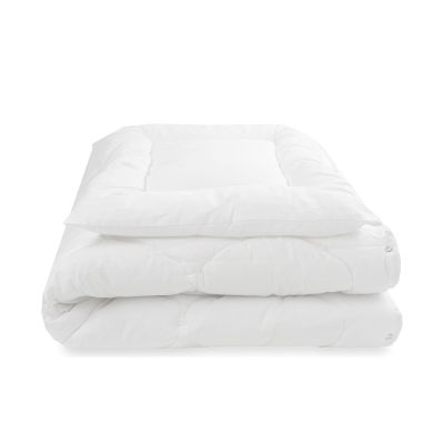 Weißes Steppbett mit aufliegendem Kissen in zusammengerollter Form von vorne fotografiert
