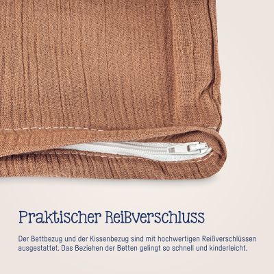 Nahaufnahme eines weißen Reißverschlusses an terrakottafarbener Musselin-Bettwäsche mit sichtbarer Stoffstruktur