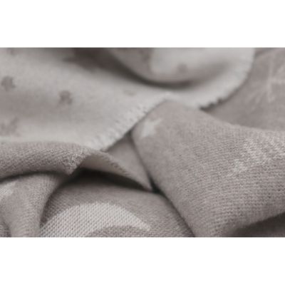 Nahaufnahme der Babydecke Universe taupe mit weicher Stofffalte und einem hellen Mondmotiv.