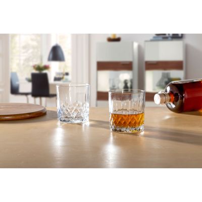 Zwei Whiskygläser eines gefüllt mit braunem Getränk daneben eine Flasche auf Holztisch